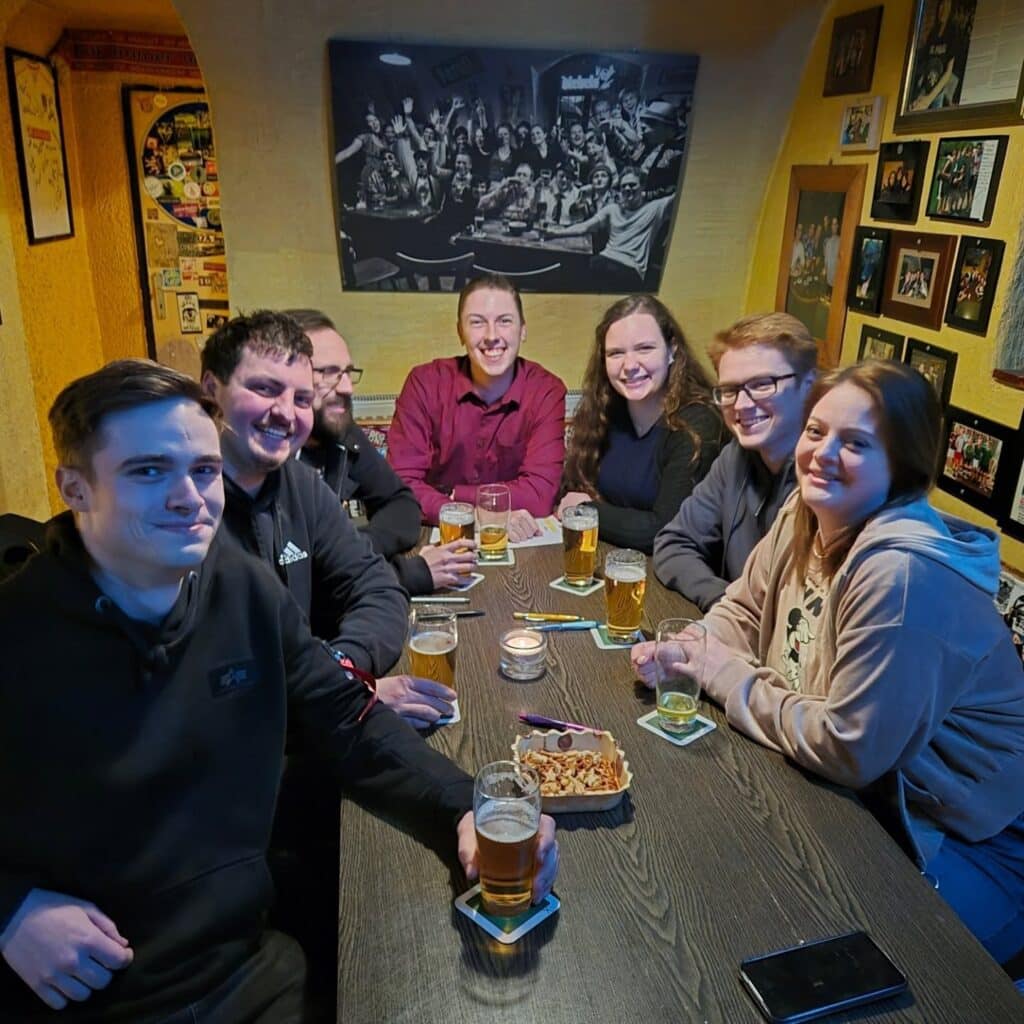 Gruppenfoto der sieben Gründungsmitglieder an einem Tisch